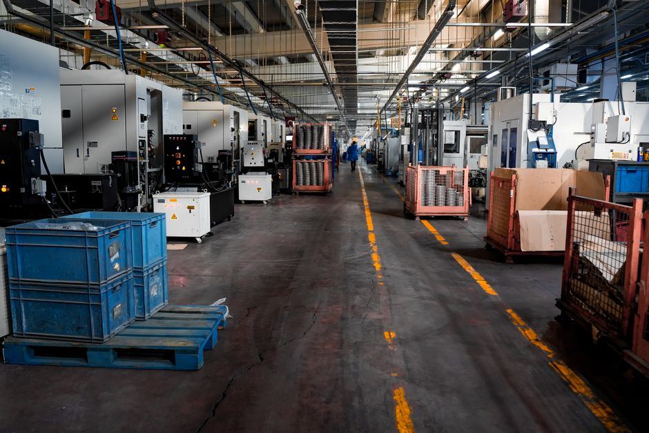 A factory floor with pallets and a marked forklift lane