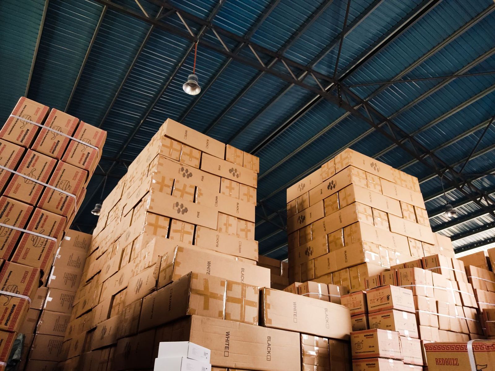 Stacks of cardboard boxes inside a large warehouse
