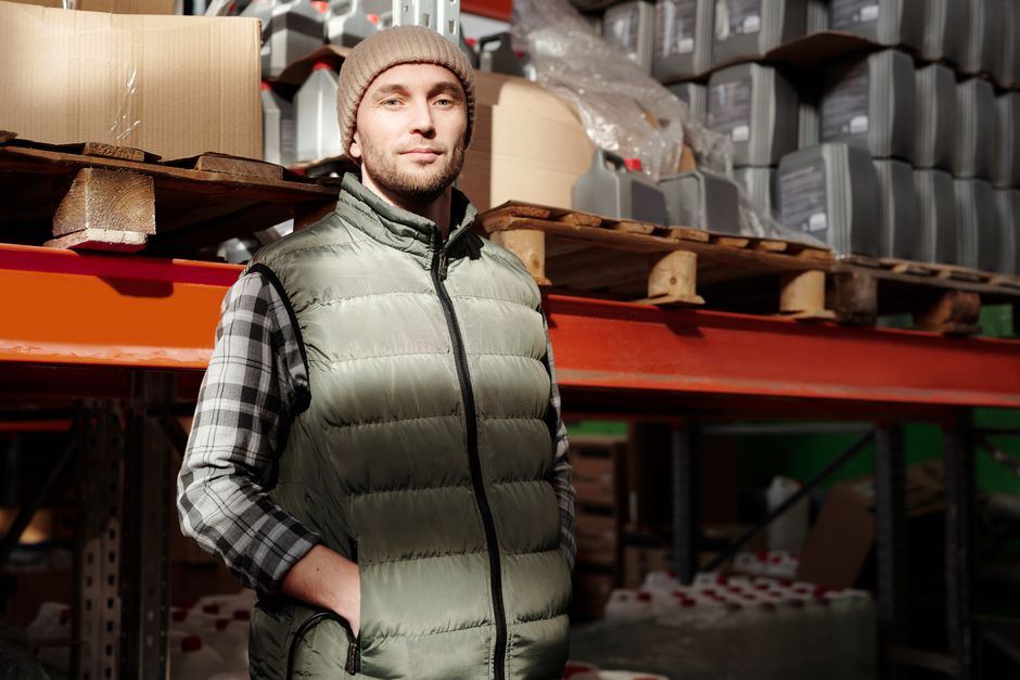 A worker standing in front of shelves in a parts storeroom