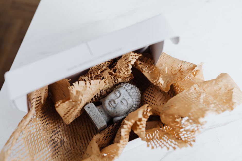 An item wrapped in paper inside a cardboard box